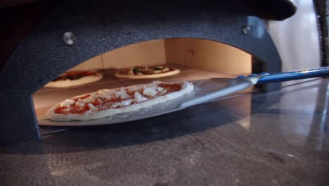 Küchenchef-Legt-Pizza-Vom-Küchentisch-In-Den-Ofen