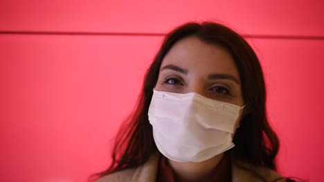 Beautiful-girl-wearing-protective-medical-mask-and-fashionable-clothes-looks-at-camera-and-be-happy