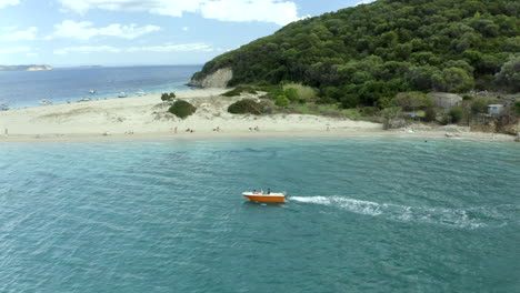 Drone-circling-a-boat-near-the-island-of-marathonisi-in-Zakynthos,-Greece