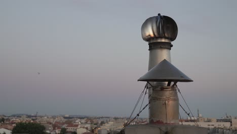 Metal-Chimney-rotating-and-residential-area-on-background