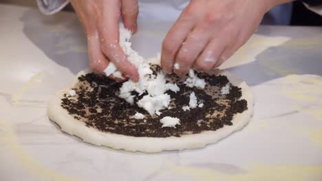 Küchenchef-Fügt-Mozzarella-Käse-Auf-Pizzateig-Mit-Trüffelsalsa-Hinzu
