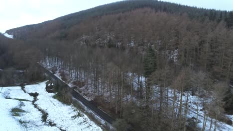 Snowy-Welsh-woodland-Moel-Famau-winter-landscape-aerial-view-orbit-left