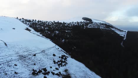 Snowy-Welsh-woodland-Moel-Famau-winter-landscape-aerial-pan-right-frozen-rural-scene