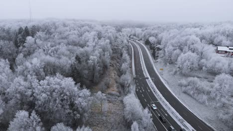 Sweden-Landscape-with-Road-and-Wintry-Snow-Covered-Trees,-Aerial-Establishing