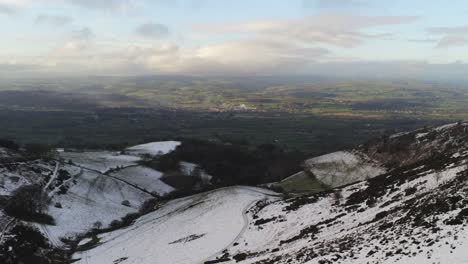 Moel-Famau-Welsh-snowy-rural-mountain-valley-aerial-view-cold-agricultural-rural-winter-landscape-dolly-left