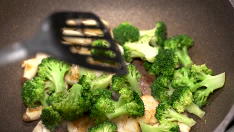 Delicious-scallops,-broccoli-and-mushrooms-being-fried-cooked-in-a-large-pan