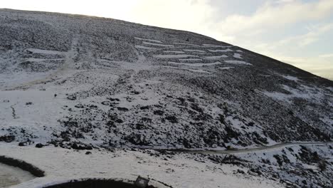 Moel-Famau-Welsh-snowy-mountain-valley-aerial-view-cold-agricultural-rural-winter-landscape-slow-right-pan