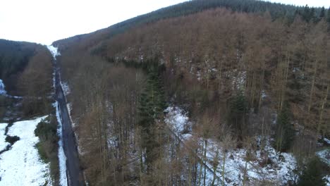 Snowy-Welsh-woodland-Moel-Famau-winter-landscape-aerial-view-above-trees