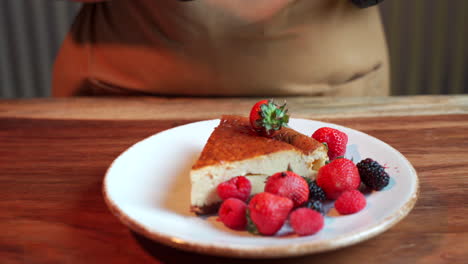 Chef-trow-berries-on-top-cheesecake