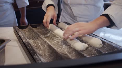 Chef-puts-the-bread-dough-into-black-baking-tray