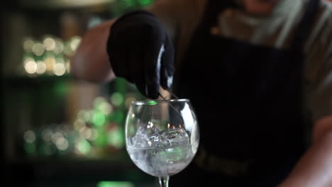 Bartender-preparing-garnishing-inside-glass-cocktail-gin-tonic