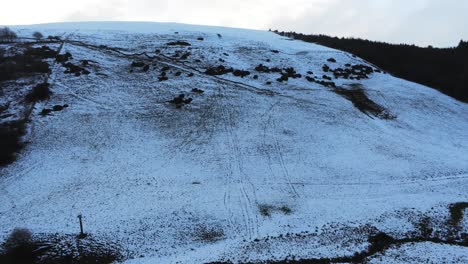 Moel-Famau-Welsh-snowy-mountain-valley-aerial-elevating-view-cold-agricultural-rural-winter-landscape