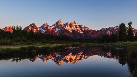 Erstaunlicher-Goldener-Sonnenaufgang-Im-Zeitraffer,-Licht,-Das-Schneebedeckten-Berg-Trifft,-Mit-Spiegelreflexion-Im-See-Bei-Der-Schwabachers-Landung,-Grand-teton-nationalpark,-Wyoming,-Vereinigte-Staaten