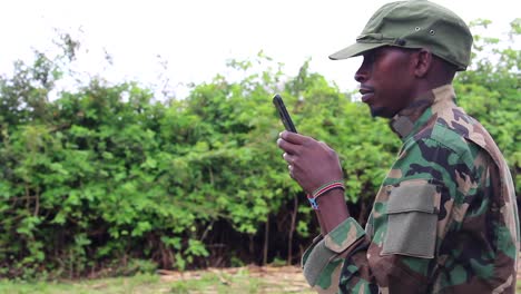 African-militant-guerilla-texting-on-phone-side-angle