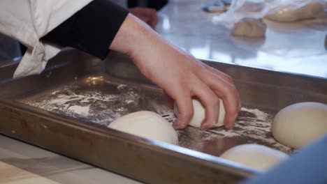 Küchenchef-Legt-Geteilte-Pizzateigstücke-In-Metallablage