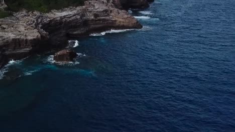 Drone-aerial-beachfront-cliffside-blue-water-Hawaii