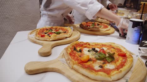 Time-lapse-of-freshly-baked-pizzas-delivered-on-kitchen-table-for-orders
