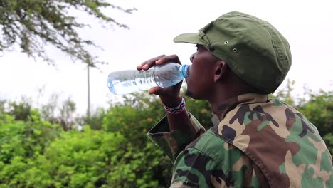 African-militant-guerilla-checks-his-water-amount-before-sipping-on-hot-day