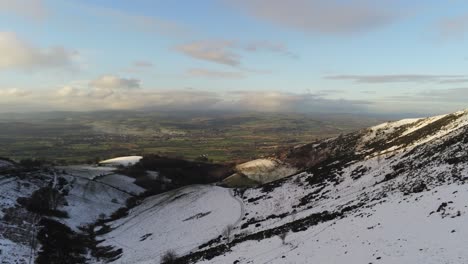Moel-Famau-Welsh-snowy-mountain-valley-aerial-rising-view-cold-agricultural-rural-winter-landscape