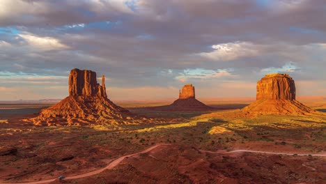 Beautiful-orange-and-pink-sunset-timelapse-with-unique-geological-rock-formations-and-clouds-flowing-in-Monument-Valley,-Arizona-United-States