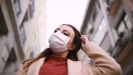 Beautiful-girl-wearing-protective-medical-mask-and-fashionable-clothes-stands-at-street