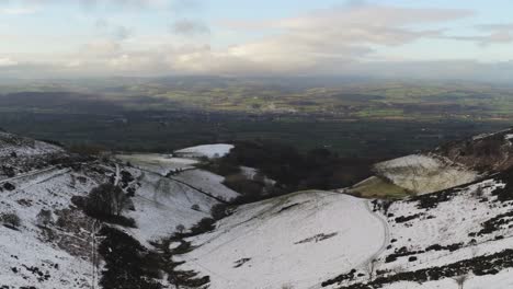 Moel-Famau-Welsh-snowy-mountain-valley-aerial-view-cold-agricultural-rural-winter-landscape-descent