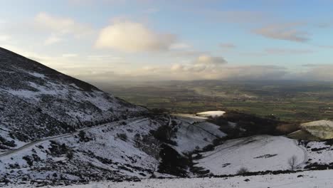 Moel-Famau-Welsh-snowy-mountain-valley-aerial-view-cold-agricultural-rural-winter-landscape-pan-right
