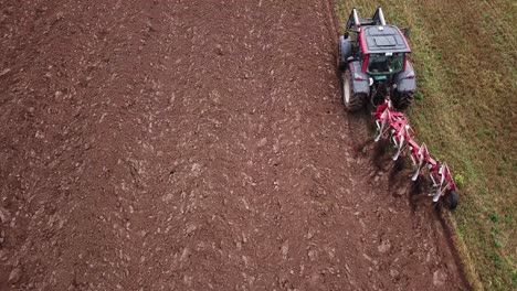 Drone-shot-of-a-tractor-plowing-fields-with-copyspace