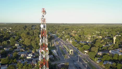 Communication-Tower-With-Antennas-and-Road-Traffic-in-Suburban-City-Area,-Aerial-View