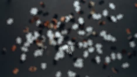 Jigsaw-puzzle-pieces-falling-down-in-slow-motion-onto-gray-table-with-shallow-close-focus-top-down-perspective-depth-of-field-out-of-focus