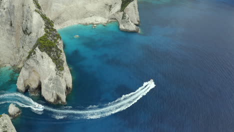 Drone-shot-of-boat-on-a-boat-your-near-shipwreck-beach-in-Zakynthos,-Greece