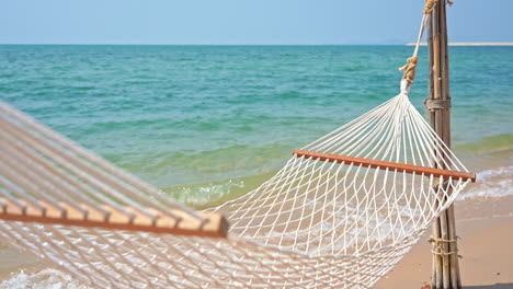 Empty-hammock-on-exotic-beach.-Focus-on-foreground