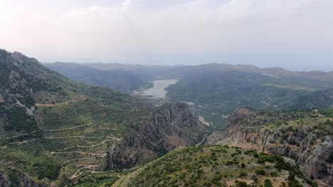 Drone-Disparó-Vista-Aérea-De-La-Carretera-De-Montaña-Y-Los-Valles-En-La-Isla-Spinelonga,-Creta,-Grecia