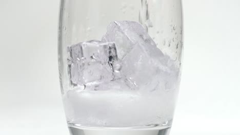 Eiswürfel,-Die-In-Glas-Fallen-Und-Dann-Mit-Soda-Oder-Sprudelndem-Wasser-Gefüllt-Werden,-Zeitlupe,-Nahaufnahme,-Produktstudio,-Zeitlupe