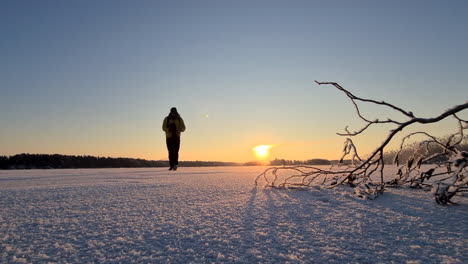 Arctic-journey-in-snow-desert,-Hiking-male-walking-across-cold-frozen-winter-landscape,-in-Vaasa,-Finland