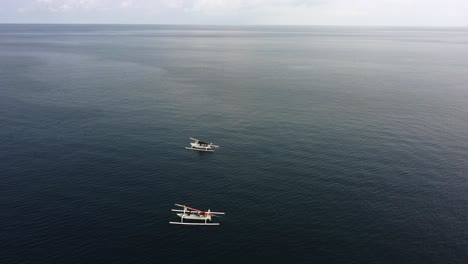 Dos-Barcos-De-Pescadores-Aislados-En-Medio-Del-Océano-Azul-En-Un-Paraíso-Tropical-Durante-Un-Día-Soleado,-Imágenes-Aéreas-Minimalistas-De-Paisajes-Zánganos