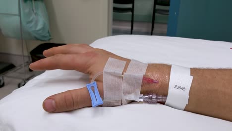 Slow-moving-hand-movements-of-unrecognizable-Caucasian-male-right-hand-in-medical-scenario-with-IV-in-wrist