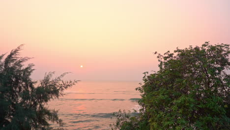 Ein-Schwenk-über-Ankommende-Meereswellen-Mit-Einem-Rosa-Und-Violetten-Sonnenuntergang