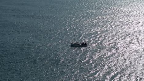 Silhouette-Eines-Fischerbootes,-Das-Von-Rechts-Nach-Links-Das-Meer-überquert