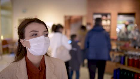 Beautiful-girl-wearing-protective-medical-mask-and-fashionable-clothes-looks-around