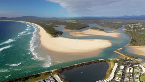 Wide-slowly-rotating-drone-shot-of-Foster-beach,-the-Nambucca-River-and-ocean-at-Nambucca-Heads-New-South-Wales-Australia