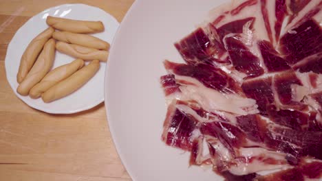 Jamon-Iberico-on-rotating-plate-by-traditional-Spanish-pico-breadsticks,-Above