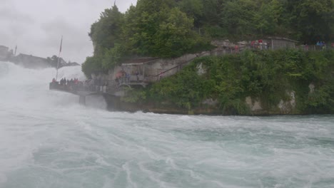 Tourists-on-Rhine-Falls-viewing-platform-as-seen-during-boat-ride