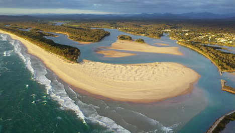 Wide-rotating-drone-shot-of-Foster-beach,-the-Nambucca-River-and-ocean-at-Nambucca-Heads-New-South-Wales-Australia