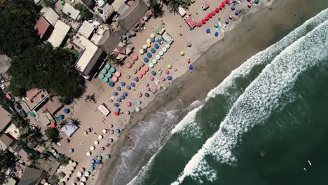 Birds-Eye-Aerial-View-of-Beach,-Ocean-Waves,-Parasols