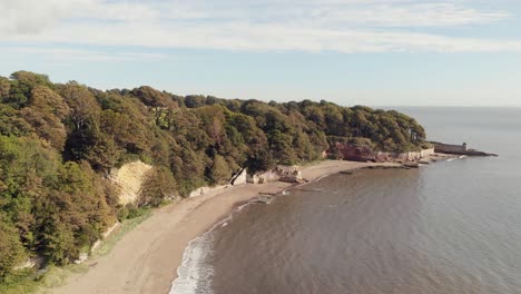 Aerial-view-along-sandy-beach-at-Ravenscraig-Fife-with-stairs-to-the-park-and-towers-in-the-distance