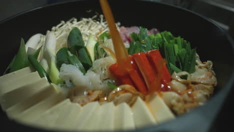 Chef-Pouring-Soup-Stock-Into-Healthy-Nabe-Hotpot