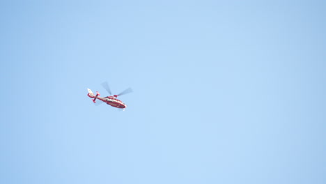 Rescue-Helicopter-Hovering-Overhead-With-Blue-Sky-In-Background-In-Tokyo,-Japan
