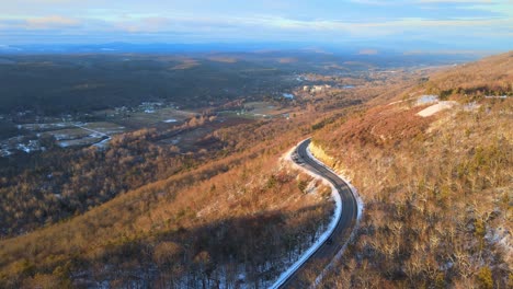 A-scenic,-winding-mountain-road-during-winter-with-light-snow