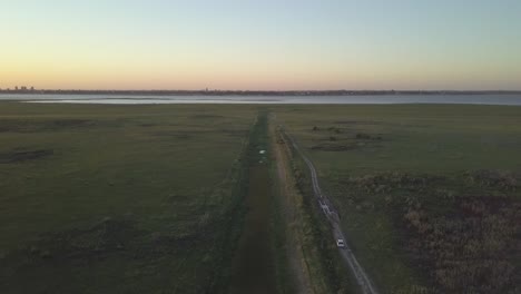 Aufsteigende-Luftaufnahme-Der-Laguna-Setubal-Mit-Der-Skyline-Von-Santa-Fe-In-Argentinien-Während-Des-Sonnenuntergangs